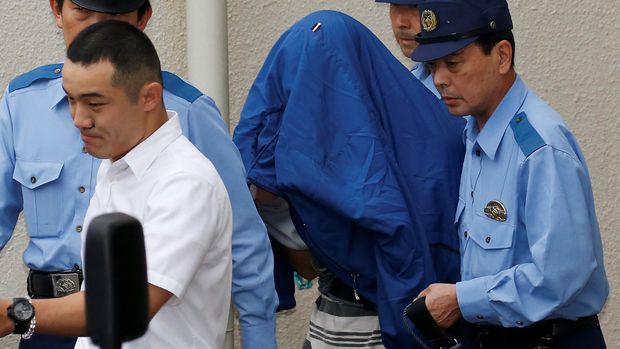 Umatsu menutupi wajahnya saat dibawa oleh Polisi setempat